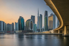 Skyline of Dubai in the evening at sunset. View of the skyscrapers from the business center. Modern buildings in the Emirates. Clear skies over the commercial buildings and the course of the bridge in the foreground